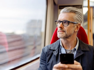 man on a train holding a mobile phone