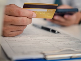 Man holding credit card and making a payment on his mobile phone