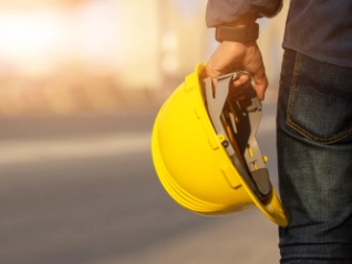 Construction worker holding safety helmet