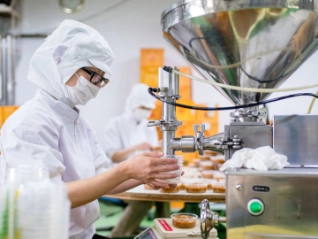 Person in protective clothing working in a food factory