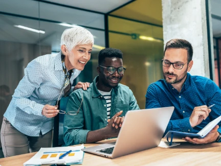 A team of 3 smiling in a meeting