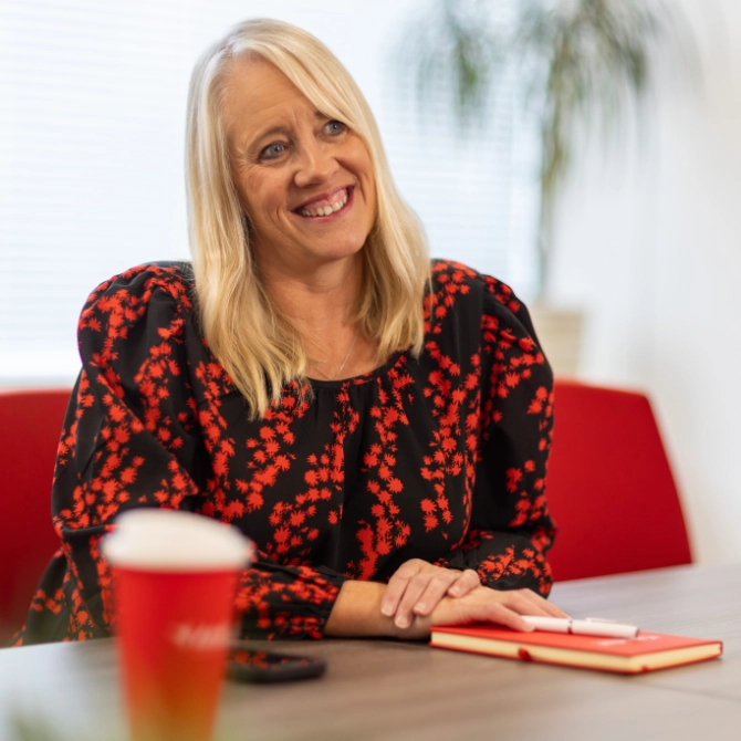 Melanie Extence Melanie Extence smiling while sat at a meeting table