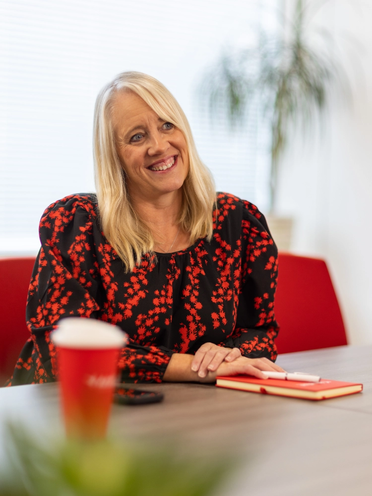 Melanie Extence smiling while sat at a meeting table