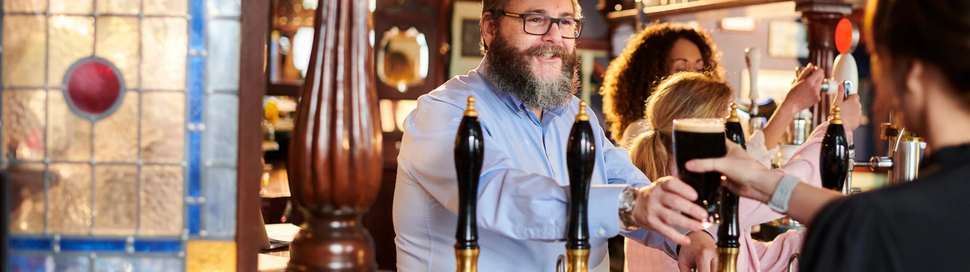 Landlord serving a customer  a pint of stout