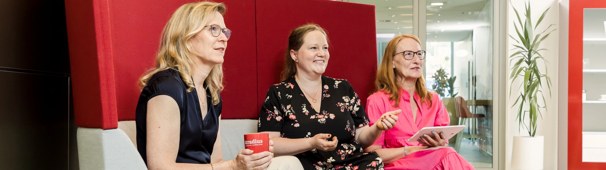 three women having a chat on a couch in the office