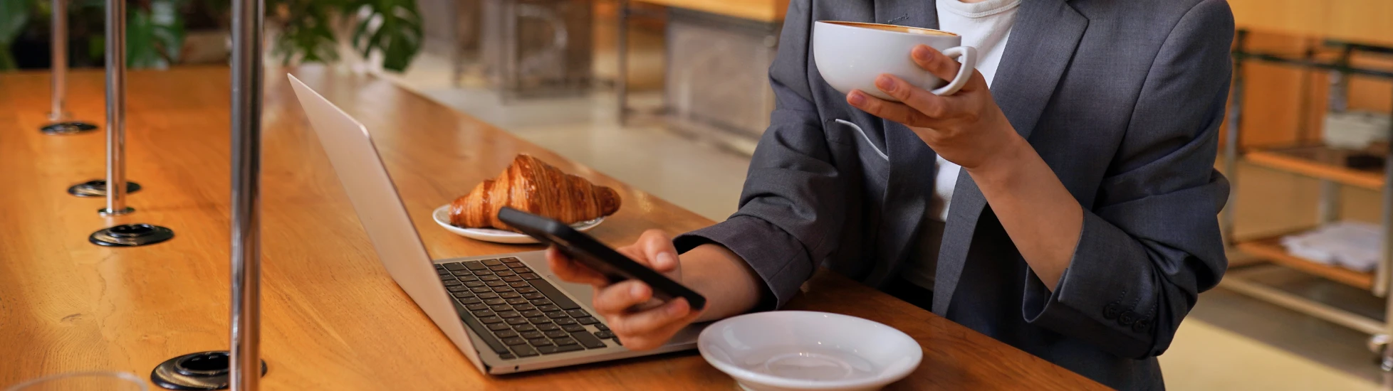 Young Asian business woman drinking coffee using smartphone in cafe