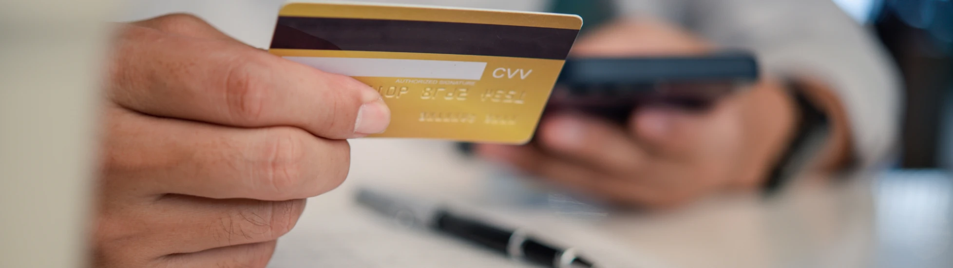 Man holding credit card and making a payment on his mobile phone