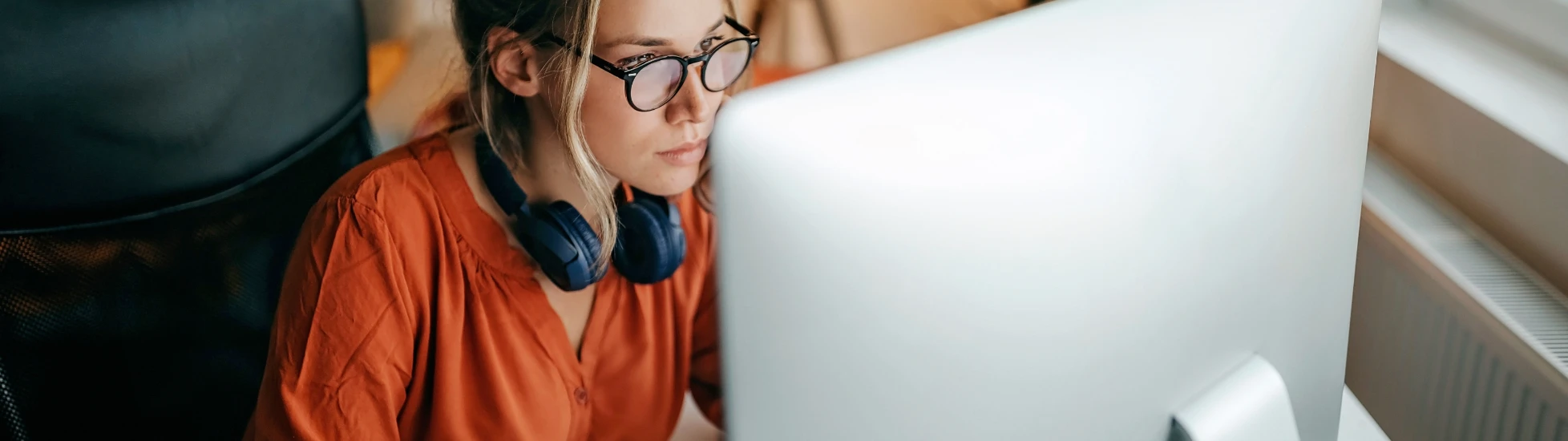 Woman with headphones working at a computer