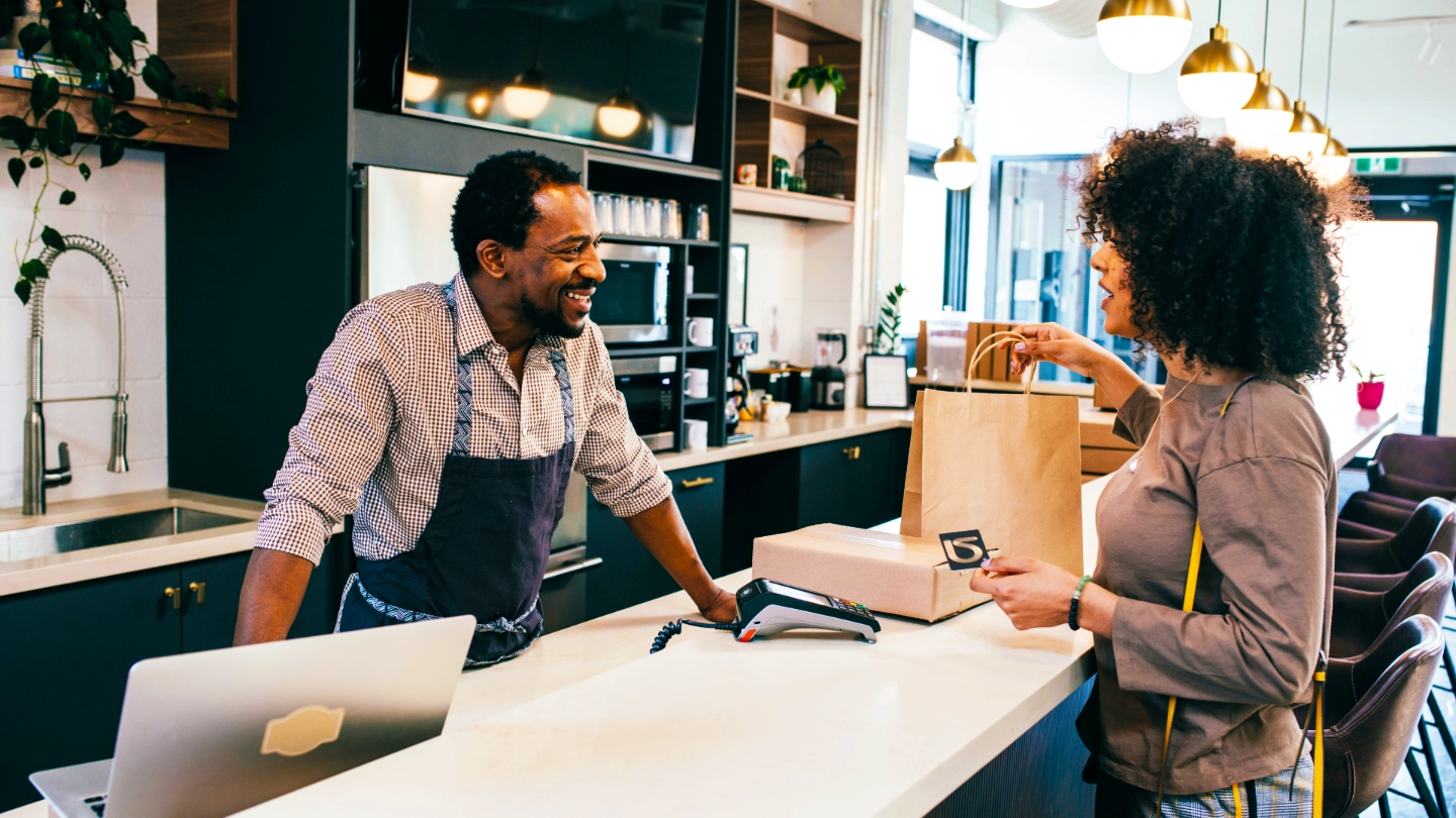 Man and woman at a cashier desk smiling