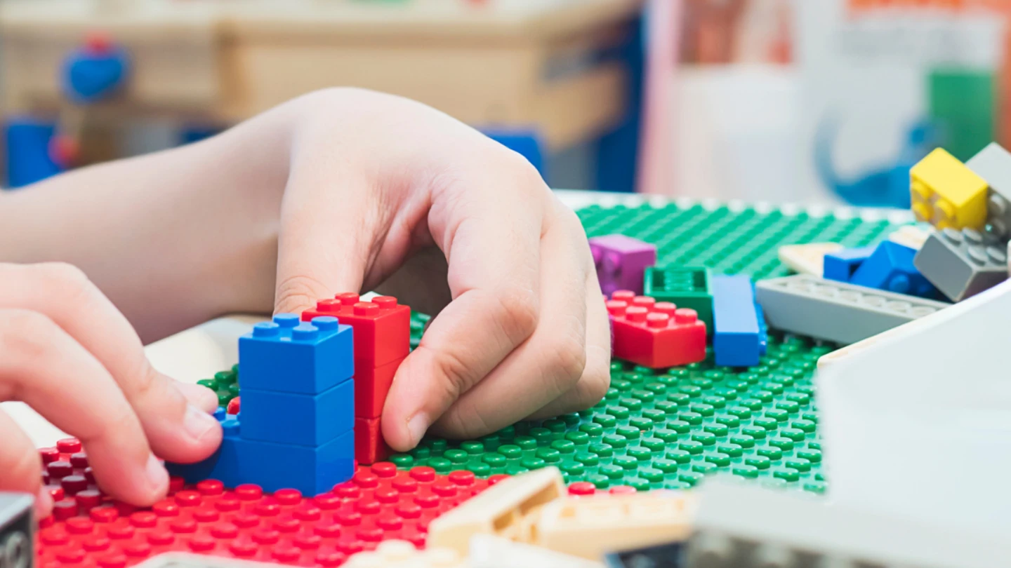 Child playing with Lego block