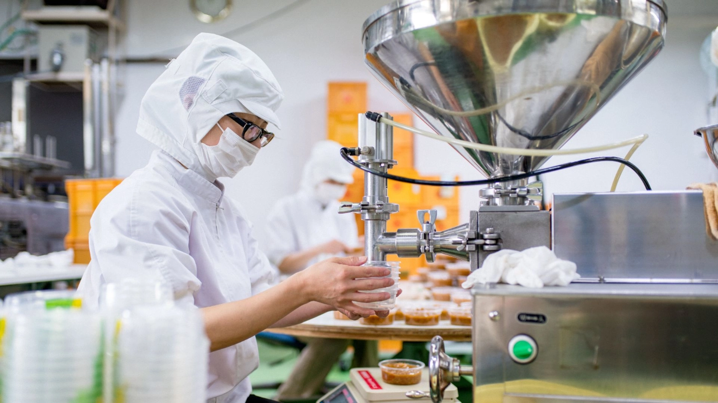 Person in protective clothing working in a food factory