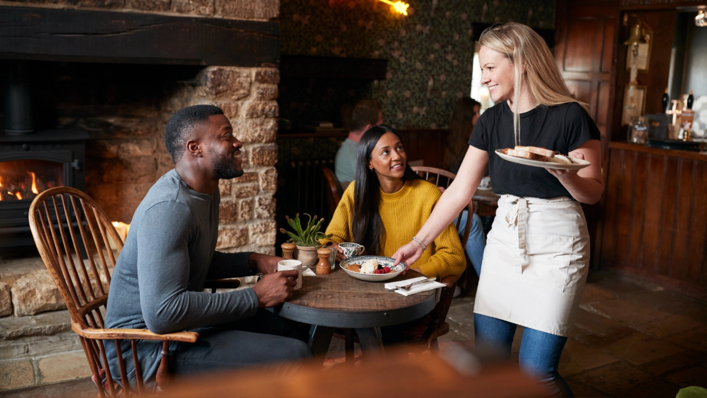 A mixed race couple being served a meal in a pub A mixed race couple being served a meal in a pub