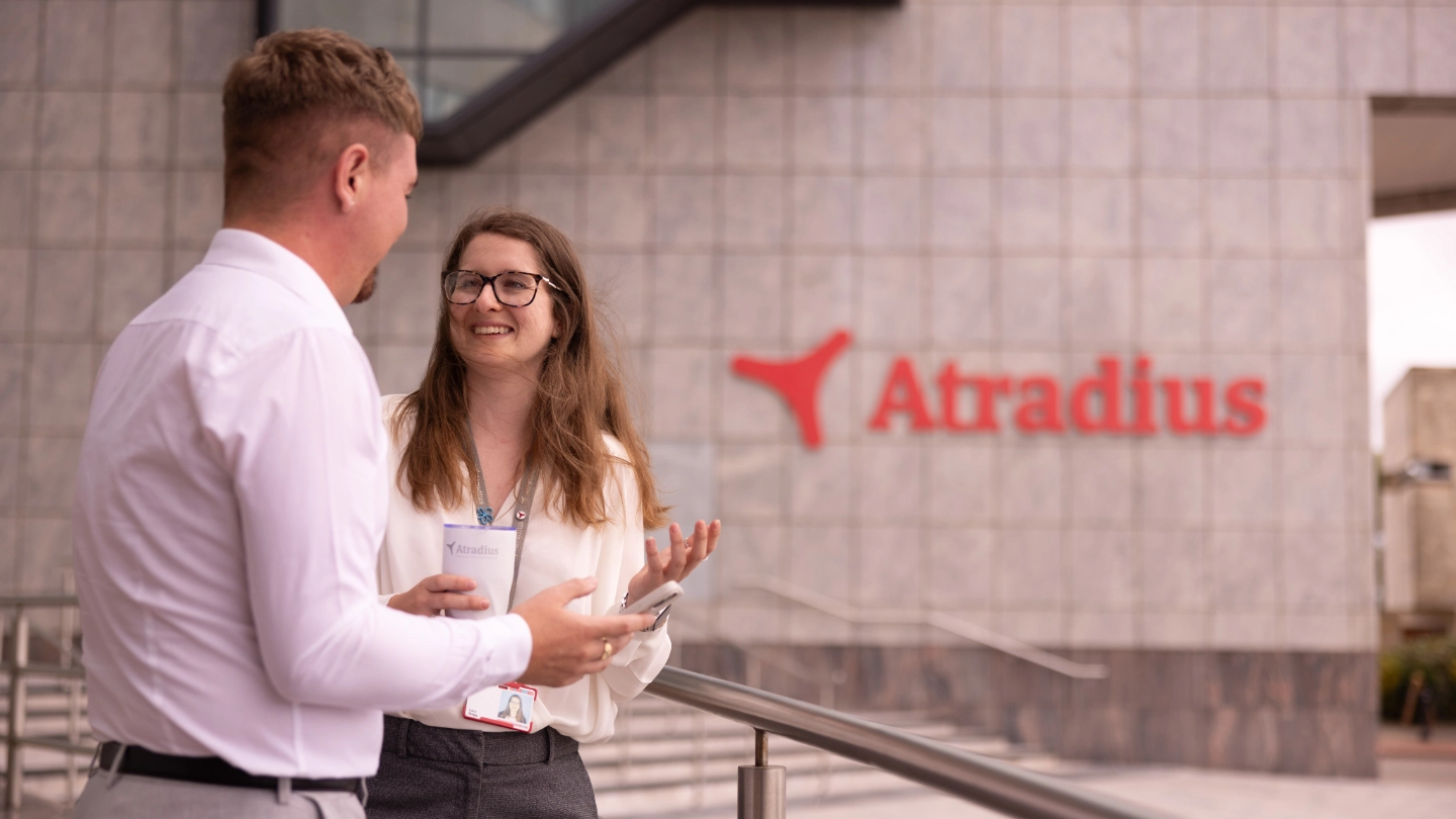 Woman and man have coffee break outside at the entrance of the Cardiff office