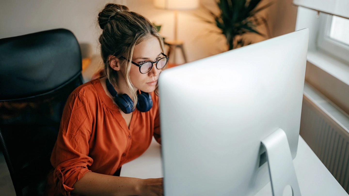 Woman with headphones working at a computer