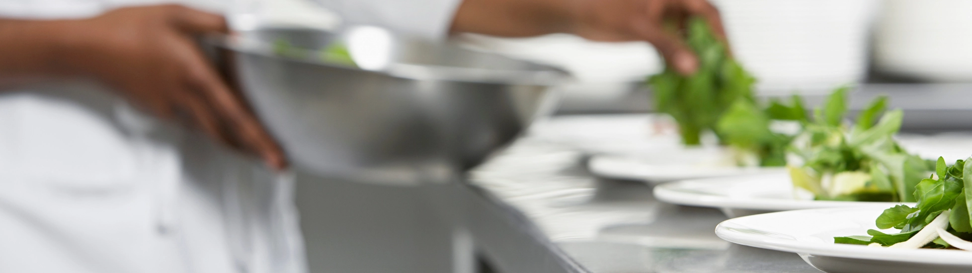 chef preparing a salad in a commercial kitchen