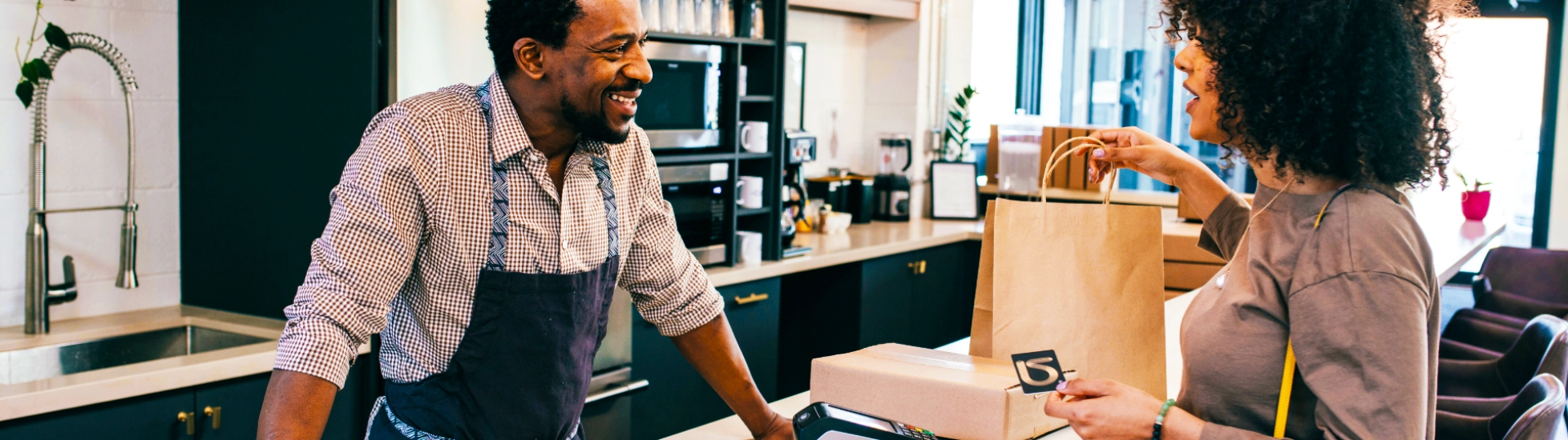Man and woman at a cashier desk smiling