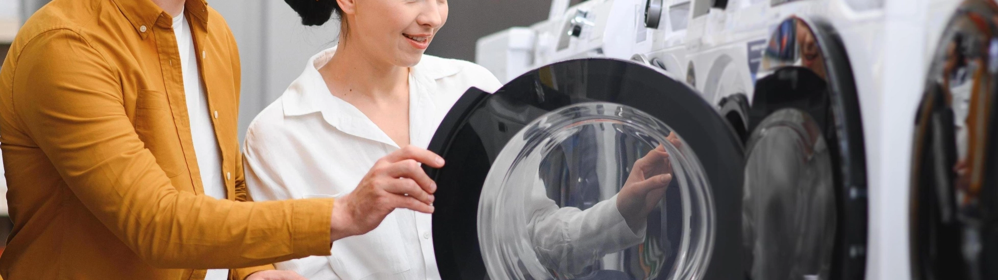 Young couple choosing washing machine in retail store