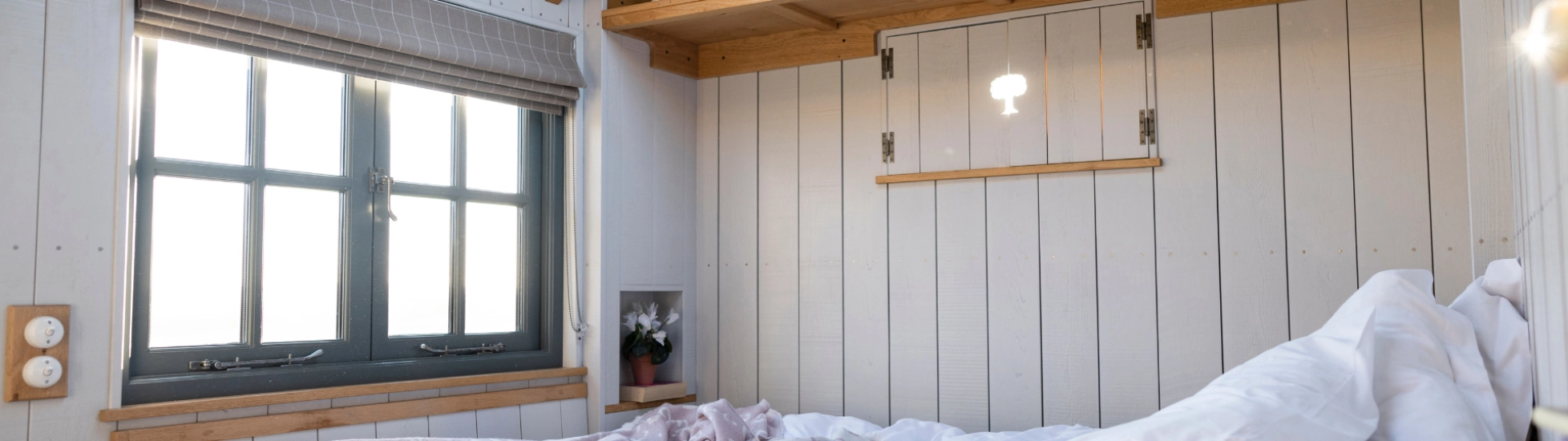 a modern glamping caravan with what walls and bedding